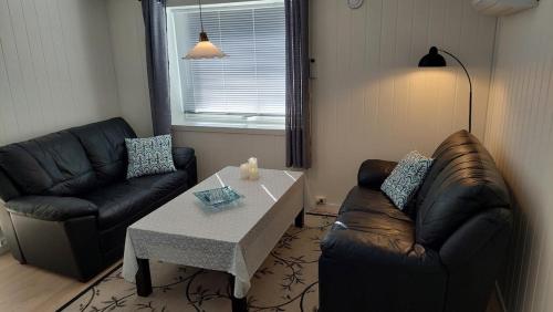a living room with a couch and a coffee table at Fishermens House, 3 bedrooms apartment near the sea Medby Senja in Senja