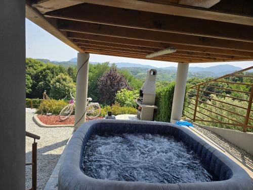 a hot tub on the patio of a house at Guest house Oasis of Peace in Gačice