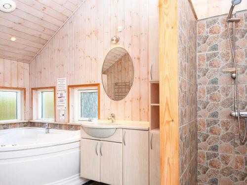 a bathroom with a tub and a sink and a bath tub at holiday home in Fårvang