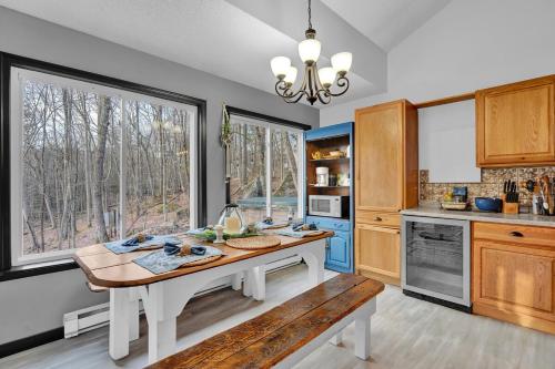 a kitchen with a table and a large window at Fall and Winter Forest Retreat Private Spa, Sauna & Ski in Lackawaxen
