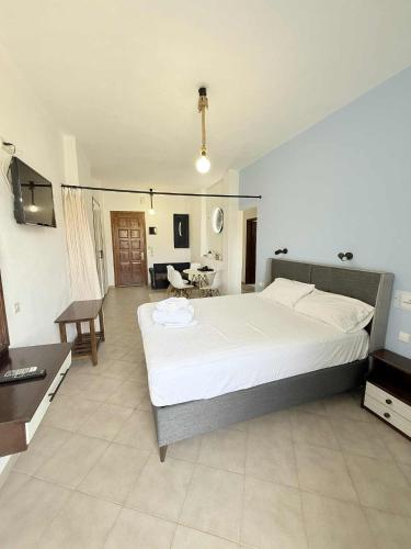 a bedroom with a large bed and a living room at Creta Star Apartments in Agia Galini