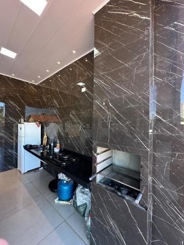 - une cuisine avec des murs en marbre noir et un comptoir dans l'établissement Rancho Fiel - Lago das Brisas, à Burity Alegre