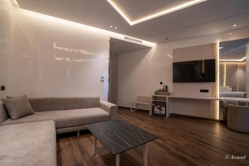 a living room with a couch and a tv at Hotel Esmeralda in Chefchaouene