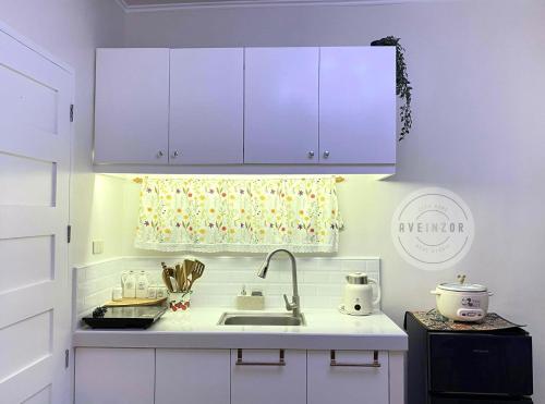 a kitchen with a sink and purple cabinets at Aveinzor Nest Studio in Dipolog