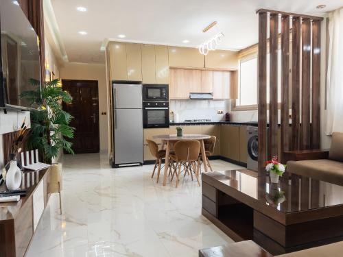 a kitchen and living room with a table and a couch at Appart de charme au centre d'Oujda in Oujda