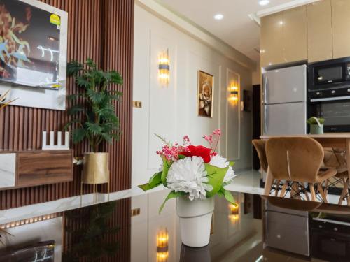 a vase with flowers on a counter in a kitchen at Appart de charme au centre d'Oujda in Oujda