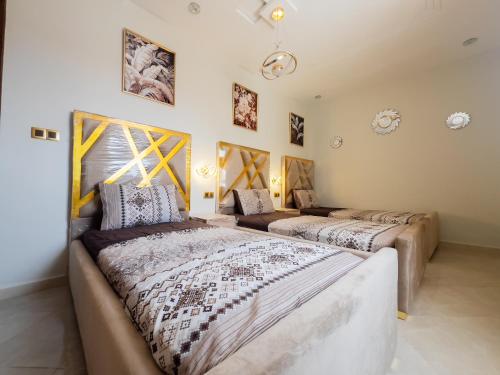 two beds sitting in a room withermottermott at Appart de charme au centre d'Oujda in Oujda