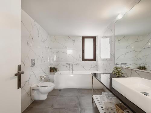 a white bathroom with a tub and a toilet and a sink at Villa Anemeli - Luxury pool villa with gorgeous seaview in Kissamos