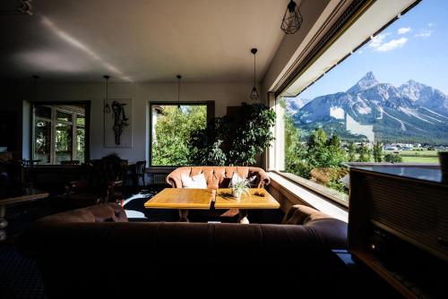 a dining room with a table and a mountain view at Mellow Mountain Hostel in Ehrwald