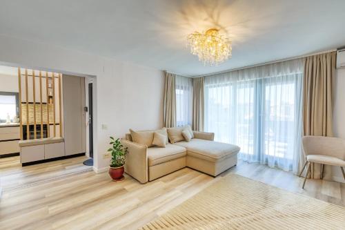 a living room with a couch and a chandelier at Casa Belsugului in Târgu-Mureş