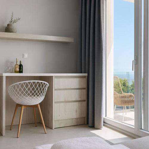 a room with a desk and a chair next to a window at Gloria Luxury Suites in Kallithea Halkidikis
