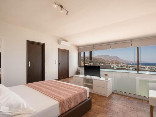 a bedroom with a bed and a flat screen tv at Villa Anemeli - Luxury pool villa with gorgeous seaview in Kissamos