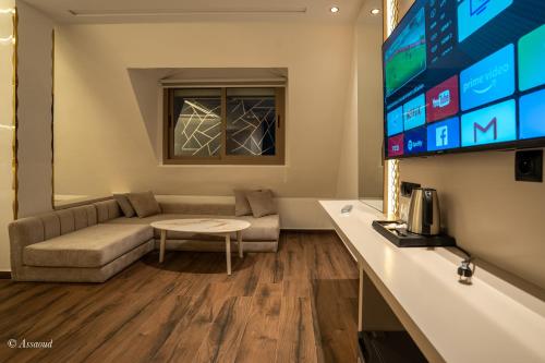 a living room with a couch and a tv at Hotel Esmeralda in Chefchaouene