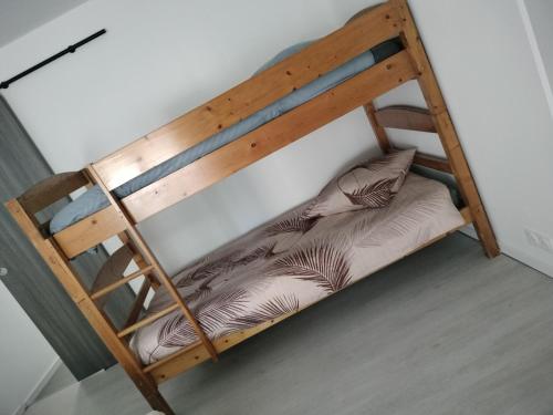 a wooden bunk bed with a pillow on it at La petite maison de poncho in Le Blanc