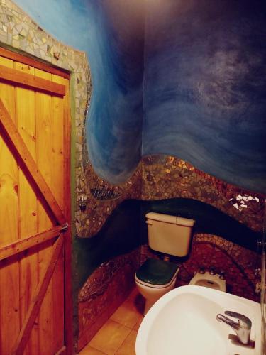 a bathroom with a toilet and a sink at Casa Zíngara Alucinante Casa de Ensueño en las Sierras in Salsipuedes