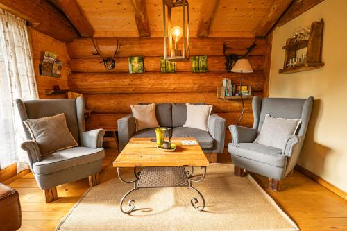 een woonkamer met twee stoelen en een tafel bij Blockhaus Mirabella in Sankt Englmar