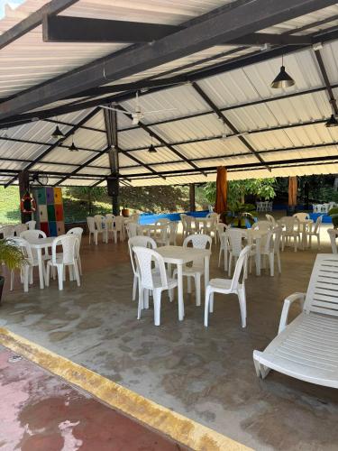 a group of white tables and chairs under a tent at Eco hotel el bosque in Doradal