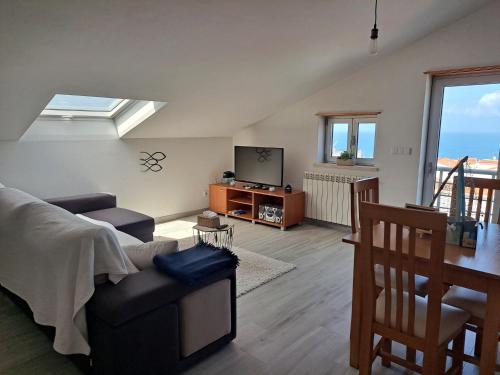 a living room with a couch and a television at Aromas do Oceano in Nazaré