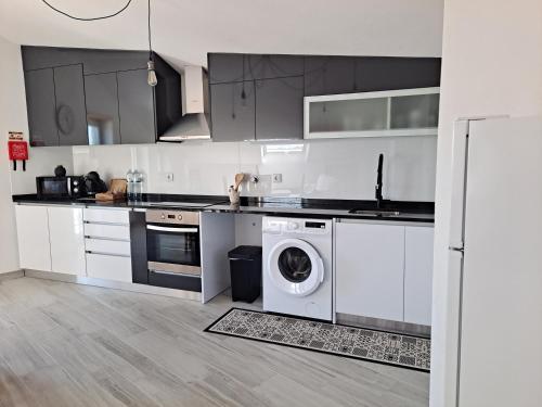 a kitchen with a washing machine and a washer at Aromas do Oceano in Nazaré