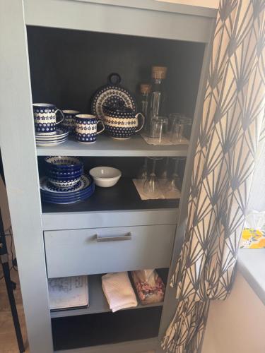 a cupboard with plates and dishes on it at Apartmán No 244 in Tábor