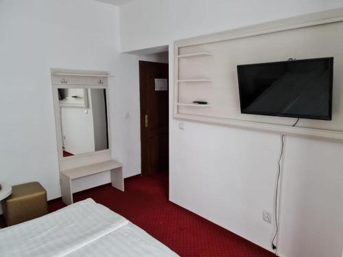 a bedroom with a tv on a white wall at Casa Vinga in Poiana Brasov