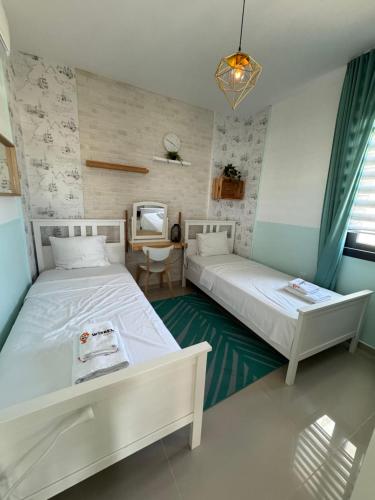 a bedroom with two beds and a tv in it at Caesar Resort & SPA - Apartment with 2 Bedroom - Aurelius in Saint Yeorgios