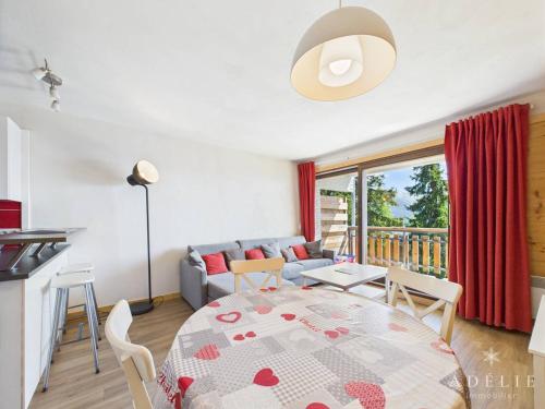 eine Küche und ein Wohnzimmer mit einem Tisch und einem Sofa in der Unterkunft Duplex refait à neuf 4/6 pers, proche remontées - FR-1-398-544 in La Rosière
