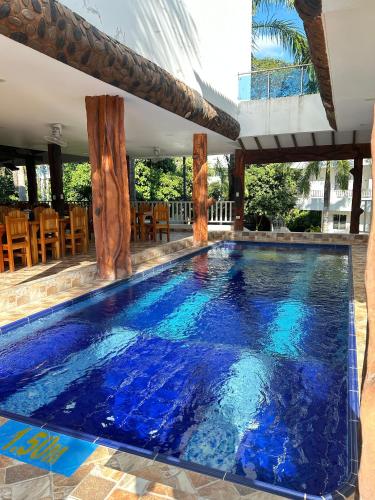a swimming pool with blue water in a house at Eco hotel el bosque in Doradal