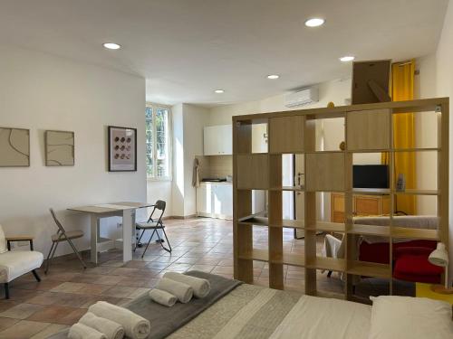 a living room with a room with a bed and a table at Michi mHOUSE Small apartment in the heart of Castelli Romani in Albano Laziale