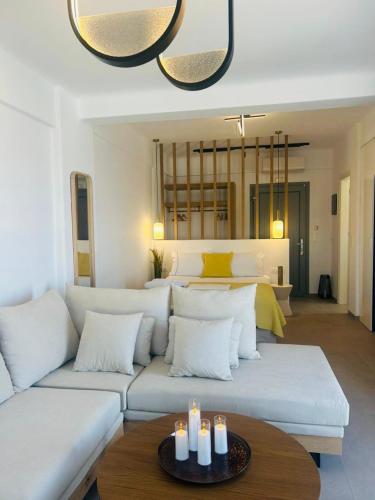a living room with a white couch with candles on a table at Gerani Deluxe Houses 2 in Astypalaia Town