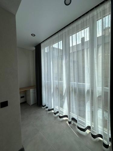 a large window with white curtains in a room at Pysanka apartments in Kolomyya