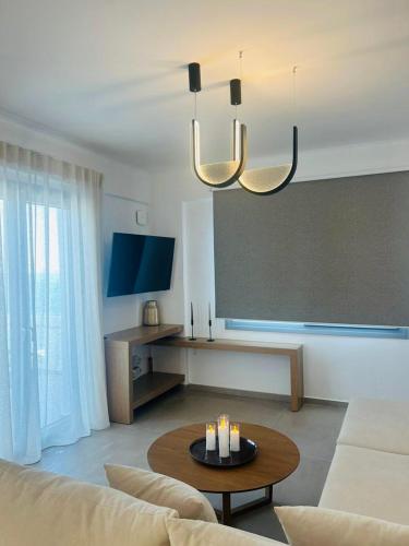 a living room with a couch and a table at Gerani Deluxe Houses 2 in Astypalaia Town