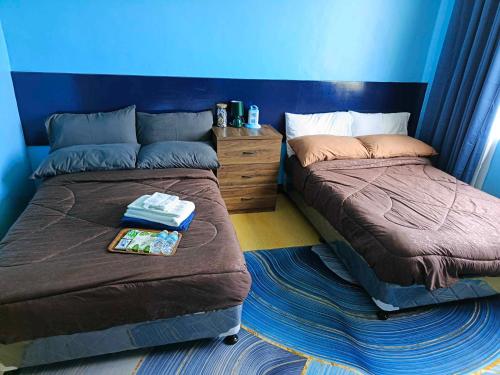 two beds sitting next to each other in a bedroom at City & Mountain View Condotel Near Ayala in Cebu City