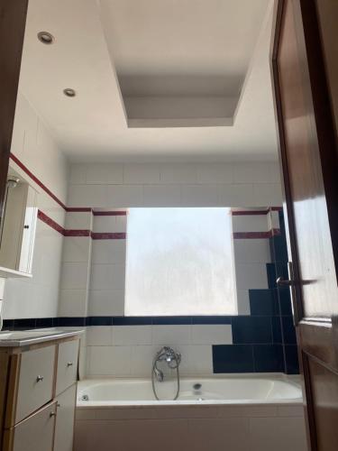 a bathroom with a bath tub and a window at Northern Comfort Apartment in Athens