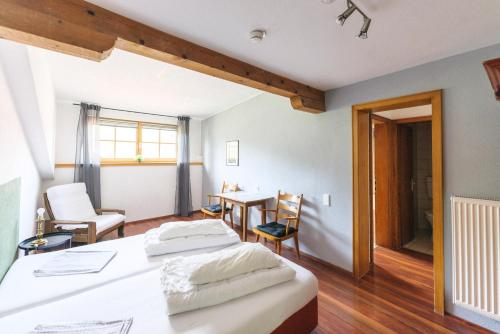 a bedroom with two beds and a table and chairs at Mellow Mountain Hostel in Ehrwald