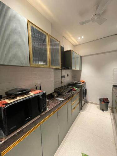 a kitchen with a stove and a microwave at Airnest Stays- Bohemian in Mumbai