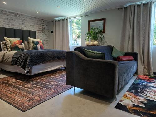 a living room with a couch and a bed at 7th Heaven Guest Cottage in Paarl