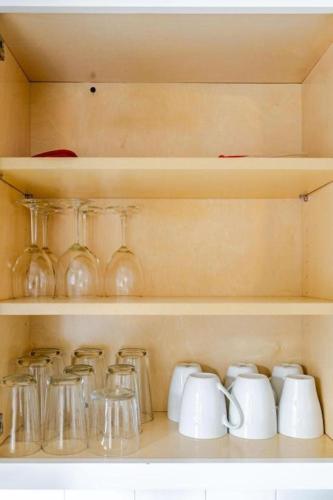 a shelf filled with glass jars and mugs at Quaint Home 310C - minutes from Uptown Charlotte in Charlotte