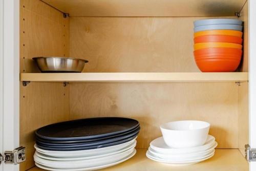 a cabinet with plates and bowls on a shelf at Quaint Home 310C - minutes from Uptown Charlotte in Charlotte