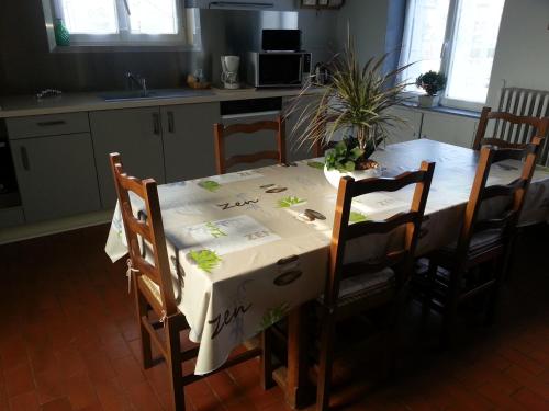 a kitchen table with a white table cloth on it at Le Tacot in Auxon-Dessus
