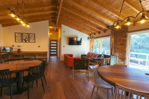 a living room with wooden ceilings and wooden tables and chairs at Aldea Molco El Pellin in Villarrica