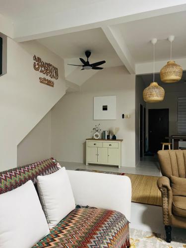 a living room with a couch and a ceiling fan at Ruma Shinkou in Kota Tinggi