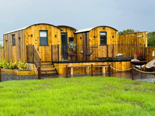 a group of wooden buildings with a deck at The Shepherds Chalet in Garstang