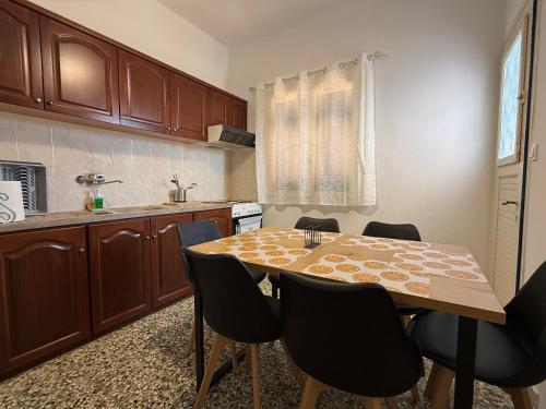 a kitchen with a wooden table and chairs at Marina Helios Home in Áyios Yeóryios