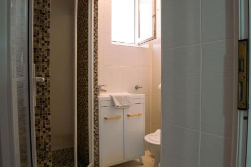 a bathroom with a toilet and a sink and a window at ElStefanino House in Eforie Nord