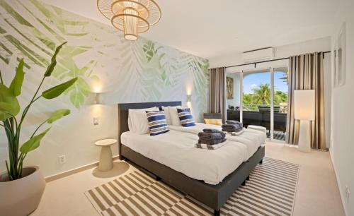 a bedroom with a large bed and a plant at Luz Abondante in Jan Thiel