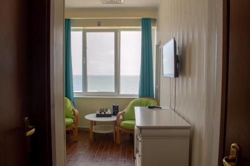 a room with a table and chairs and a window at ElStefanino House in Eforie Nord