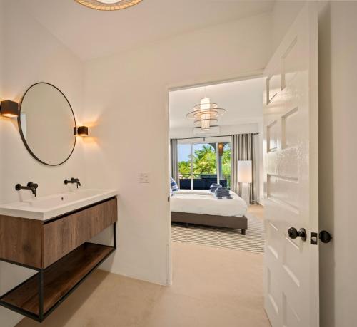 a bathroom with a sink and a mirror and a bed at Luz Abondante in Jan Thiel