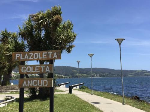 a sign in front of a body of water at Restaurant, Cabañas y Hotel Polo Sur in Ancud