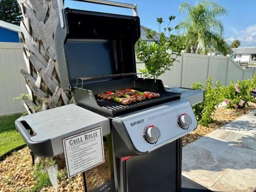 a grill with a bunch of food cooking on it at Brand New Pool! Waterfront Canal Luxury Home in Apollo Beach